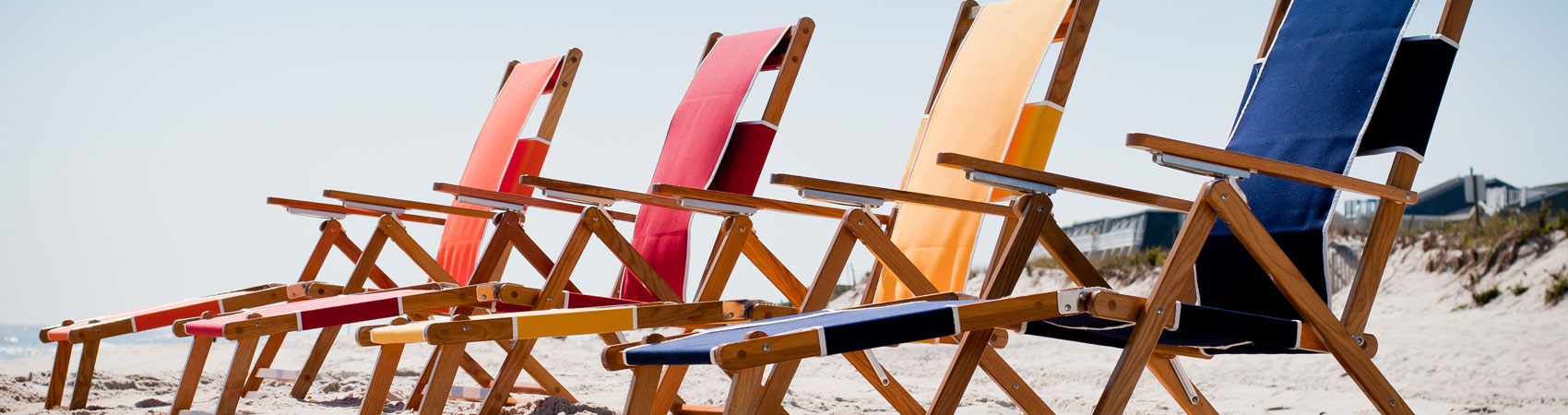 Four Frankford Beach Oakwood Loungers set up on the beach sand