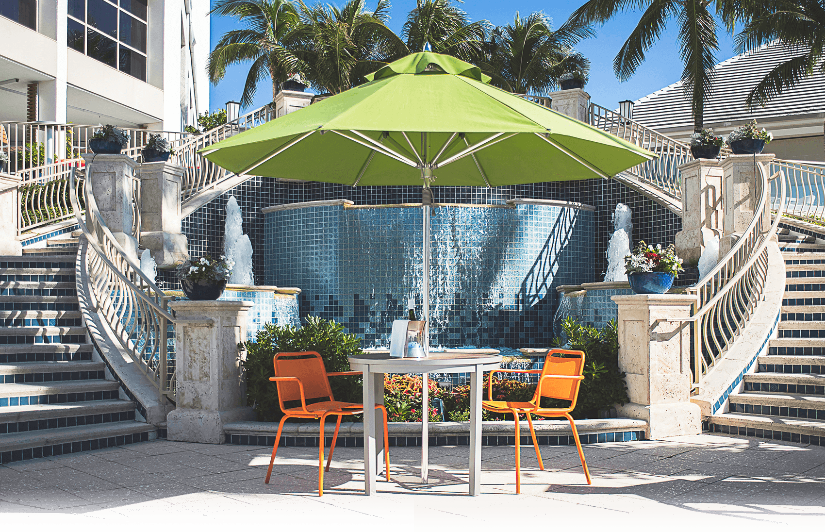 Green Frankford Greenwich Market Umbrella with table and chairs, used in a hospitality setting